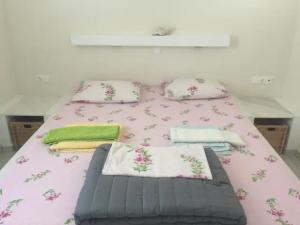 a bedroom with a pink bed with pillows at Cycladic house in rural surrounding 2 in Amorgos