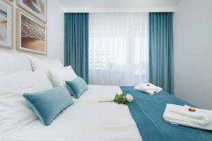 Un pat sau paturi într-o cameră la Baltini Premium Apartament Bliżej Morza