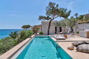 a swimming pool with a view of the ocean at Marconi's seaside villa in Megas Gialos - Nites