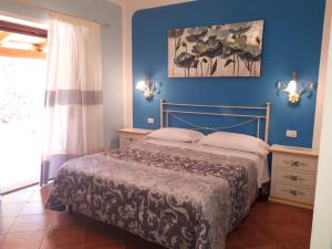 a bedroom with a bed and a blue wall at B&B Da Sabrina in San Teodoro