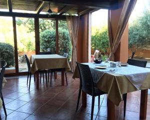 a dining room with tables and chairs and a large window at B&B Da Sabrina in San Teodoro
