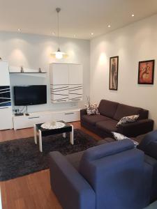 uma sala de estar com 2 sofás e uma televisão de ecrã plano em Apartment Centar Omis em Omiš