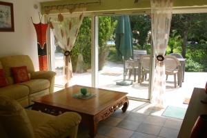 a living room with a coffee table and a sliding glass door at A la Verte Campagne in Roquebrune-sur-Argens