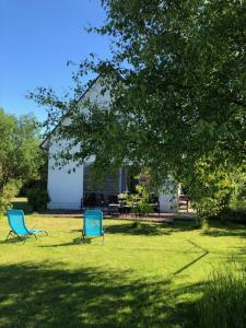 two blue chairs sitting in the grass in front of a house at Ferienhaus Dierhagen in Dierhagen