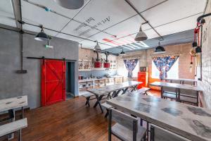 a restaurant with wooden tables and a red door at Wasser отель, трасса M4 in Voronezh