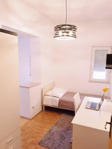 a bedroom with a bed and a desk with a laptop at Apartment Centar Omis in Omiš