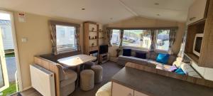 a caravan living room with a couch and a table at The Shack - plot NB139 in Porth