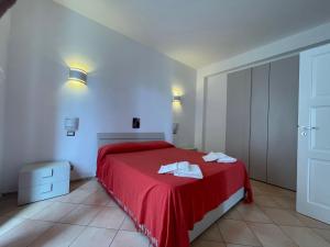 a bedroom with a red bed with towels on it at Suite De Pasquale Lipari in Lipari