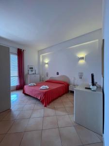 a bedroom with a red bed and a desk with a television at Suite De Pasquale Lipari in Lipari