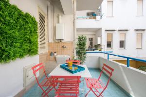 een patio met een tafel en stoelen op een balkon bij Vento di Grecale - a pochi metri dal mare in Santa Flavia