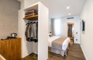 
a bedroom with a bed and a dresser at Peninsular in Girona
