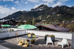 un patio con mesa, sillas y montañas en VIERKLEE - Das kinderfreundliche Ferienhaus am Achensee, en Maurach