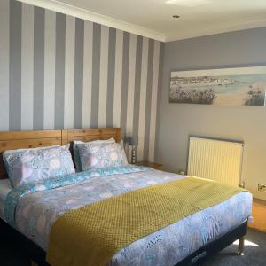 a bedroom with a bed and a striped wall at Southbank Guesthouse in Elgin