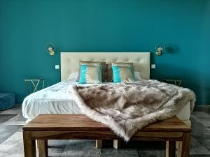 a bedroom with a bed with a blue wall at Auberge Ferayola in Galeria +70 photos