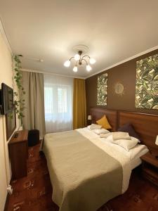 a bedroom with a large bed and a television at Vernisage on Ushinskogo in Saint Petersburg