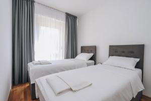 two beds in a room with a window at Status-M Аpartments 173 in Bečići +24 photos