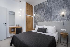 a bedroom with a bed and a concrete wall at Remezzo Bayfront Suites in Livadi Astypalaias