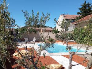 a swimming pool in front of a house at Le Clos des Evigneaux in Rasteau