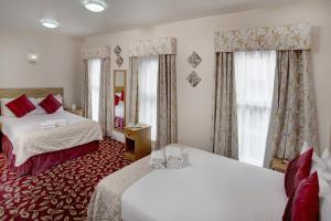 イルフォードにあるベスト ウエスタン グレーター ロンドンのベッド2台と窓が備わるホテルルームです。