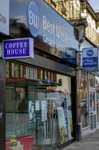 uma loja com placas na lateral de um edifício em Best Western Greater London em Ilford