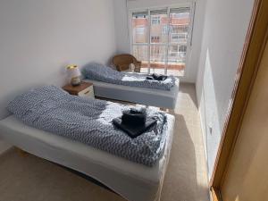 2 camas individuales en una habitación con ventana en Puerto y Mar Apartments, en La Manga del Mar Menor