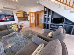 a living room with a couch and a glass table at Puerto y Mar Apartments in La Manga del Mar Menor