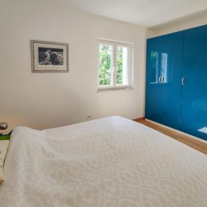 a bedroom with a large bed and a blue cabinet at Seaside House PuntaSkala in Petrcane