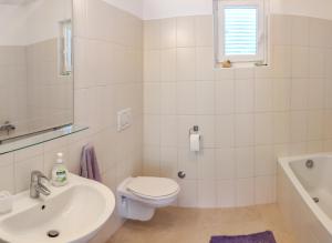 a white bathroom with a toilet and a sink at Seaside House PuntaSkala in Petrcane +29 photos
