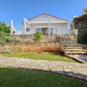 a house with stairs and a stone wall at Seaside House PuntaSkala in Petrcane