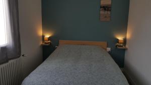 sypialnia z łóżkiem z dwoma światłami na ścianie w obiekcie Git'appart w mieście Airaines