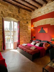 a bedroom with red walls and a large bed at Affittacamere B&B Carella in Palermo