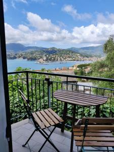 una mesa y sillas en un balcón con vistas al agua en Tra Sole & Mare, en Zoagli