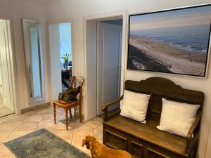 a dog standing in a living room with a bench at Kliffssand 33 in Kampen