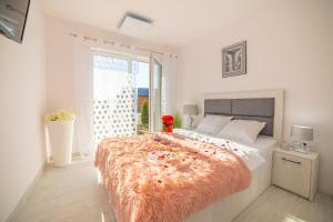 sypialnia z dużym łóżkiem i pomarańczowym kocem w obiekcie Apartamenty Scarlet w mieście Darłowo