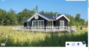 Ein schwarzes Haus auf einem Rasen in der Unterkunft Nordjutland - Kattegat in Aså