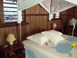 a bedroom with a bed with a turtle on it at Komba Forever in Nosy Komba