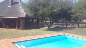a house with a swimming pool in front of a building at Makhato Bush Lodge 86 in Bela-Bela