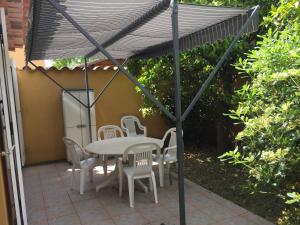 a table and chairs under an umbrella on a patio at STUDIO PIED DANS L EAU in La Londe-les-Maures +2 photos