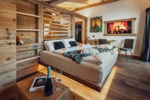 una camera con un letto in una stanza con pareti in legno di Hotel Ciasa Lorenzi a Cortina dʼAmpezzo