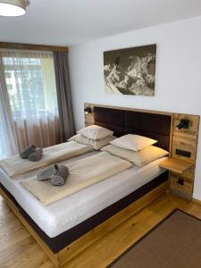 duże łóżko z dwoma poduszkami na górze w obiekcie Apartment Luna incl Summercard Zell am See Kaprun w Kaprunie