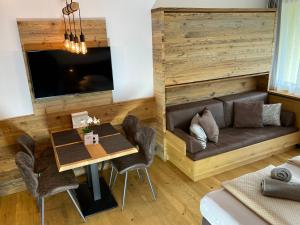 jadalnia z kanapą, stołem i krzesłami w obiekcie Apartment Luna incl Summercard Zell am See Kaprun w Kaprunie
