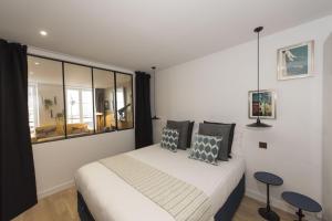 1 dormitorio con cama y ventana grande en Balthazar en París