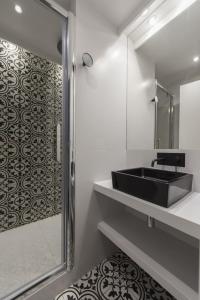 baño con lavabo negro y espejo en Balthazar en París