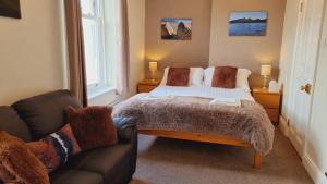 1 dormitorio con 1 cama y 1 sofá en Herdwick Guest House en Keswick