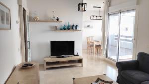 een woonkamer met een flatscreen-tv op een tafel bij Valle Romano Golf Resort Estepona in Estepona