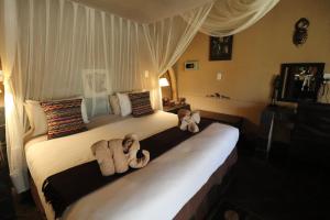a bedroom with two beds with towels on them at African Rock Lodge in Hoedspruit
