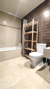 a bathroom with a toilet and a sink and a tub at Valle Romano Golf Resort Estepona in Estepona