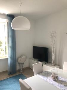 a living room with a tv and a table with chairs at Acquamarina in Forte dei Marmi
