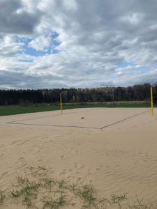 an empty volleyball court with two yellow posts in the sand at dom do wynajecia oaza in Leszyce