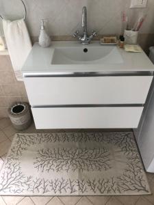 a bathroom with a white sink and a rug at Acquamarina in Forte dei Marmi +19 photos